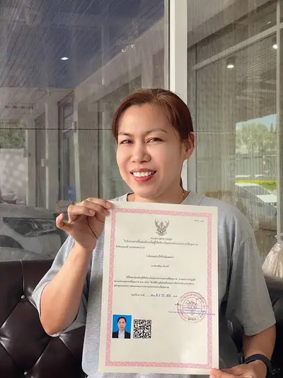 นักเรียนโรงเรียนสอนนวดโดยหมอไมเคิลถือใบขึ้นทะเบียนหมอนวด สพส.14 ใบที่ 6
